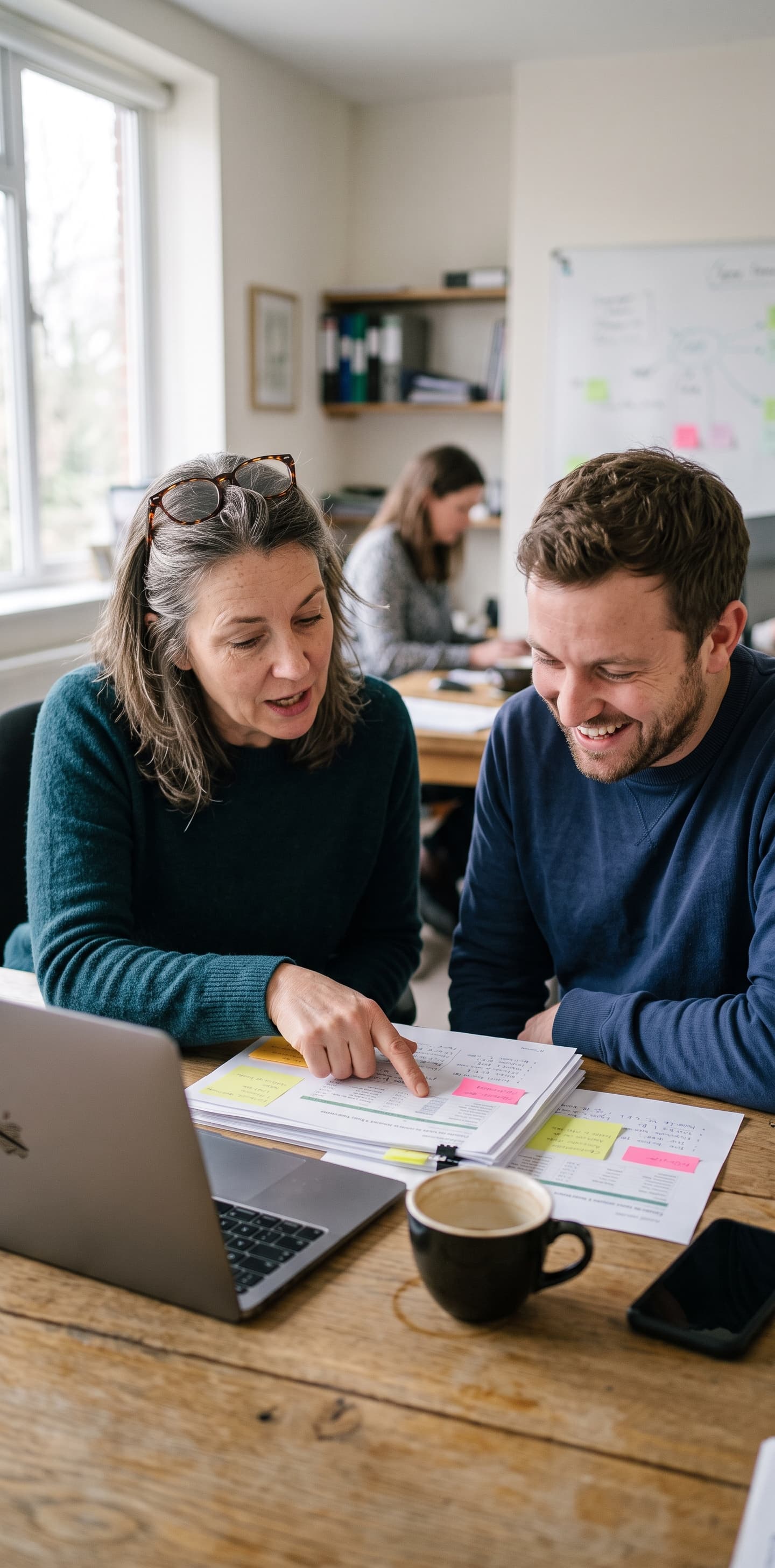 Two colleagues going through a project on a laptop